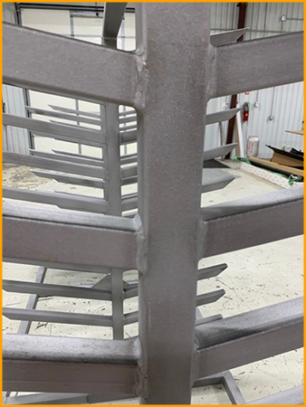  Steel racks are sanded and primed for polyurea coating. 